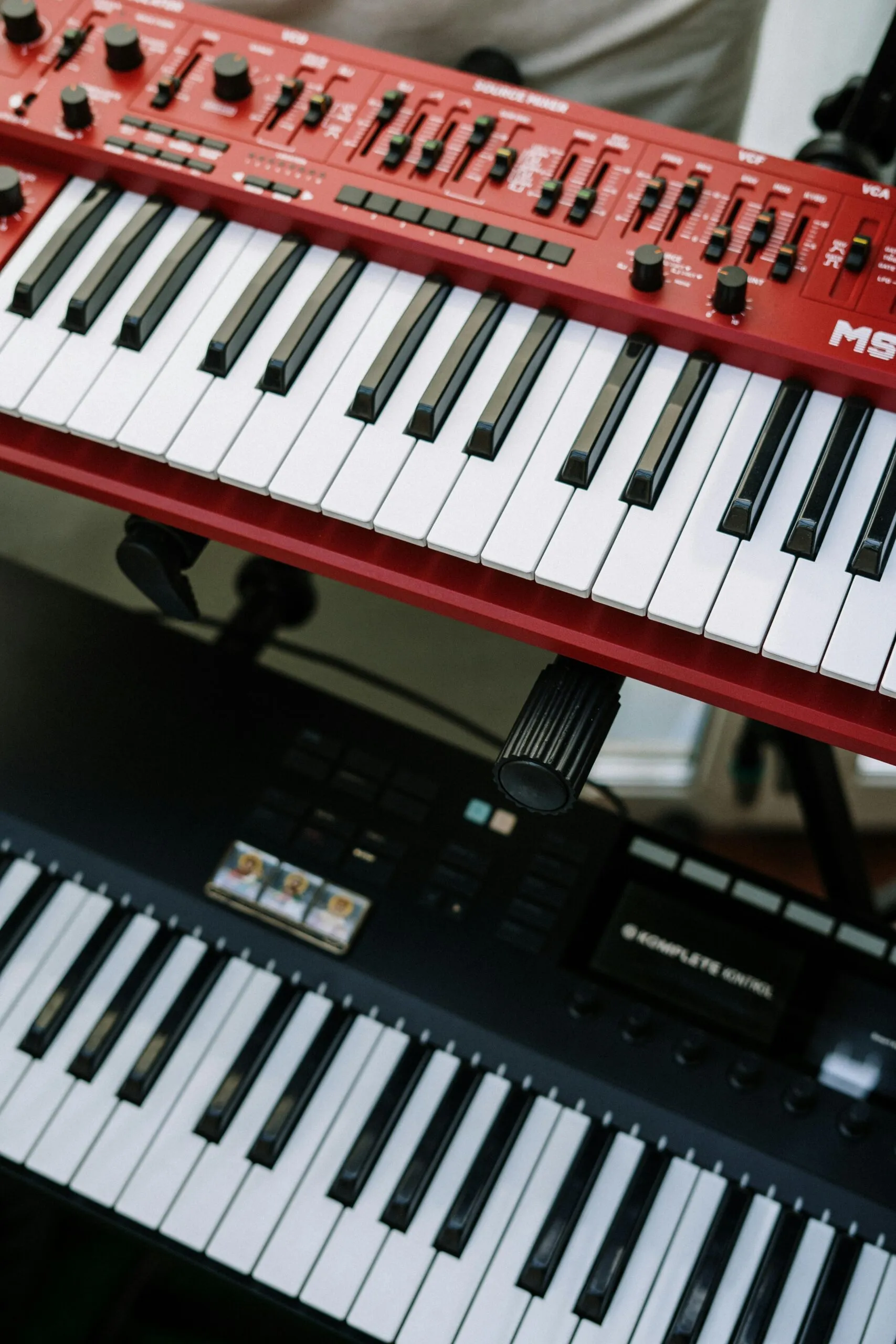 Een rode synthesizer boven een zwart MIDI-keyboard